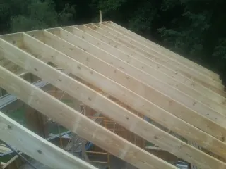 New roof rafters set over an addition before sheathing in Weston